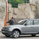 A photo of two people rock climbing near a BMW X3 SUV.